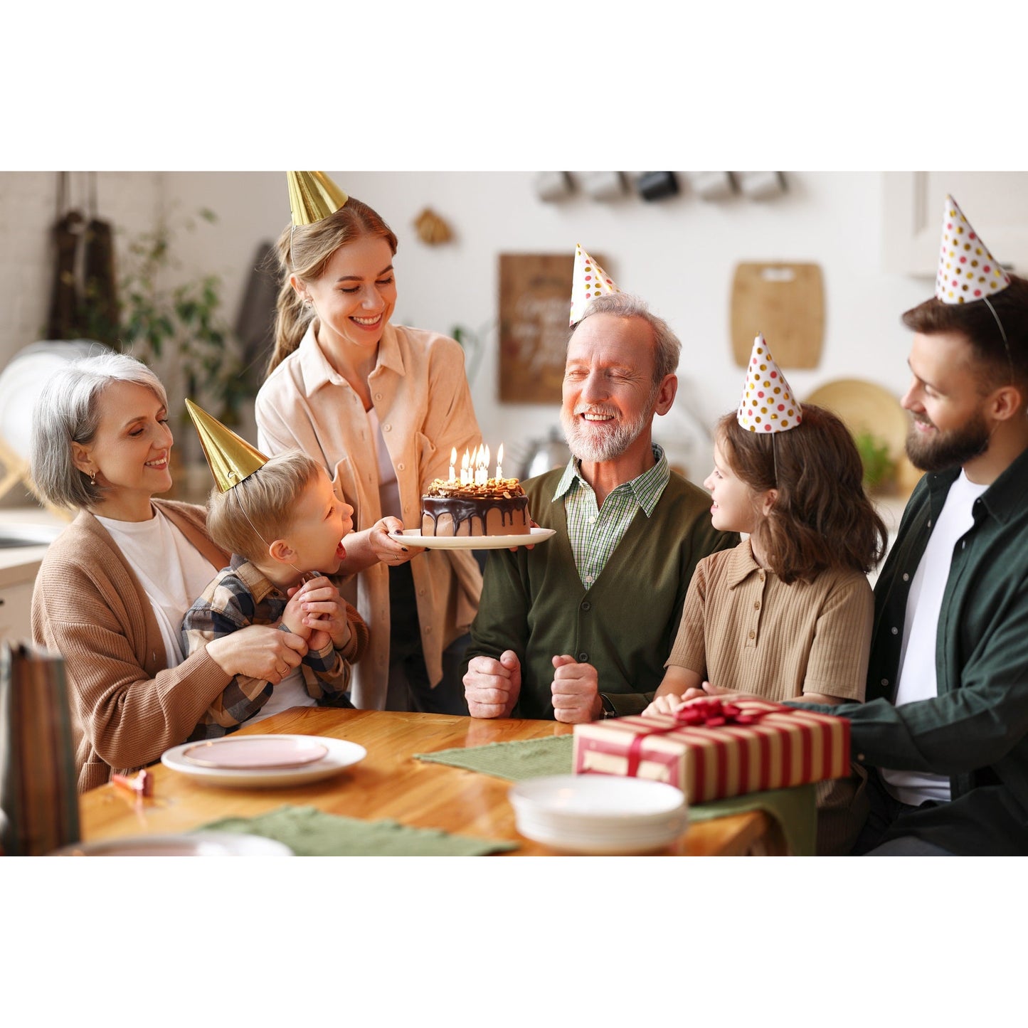 Familie feiert Geburtstag mit Kuchen und Geschenk, geeignet als Anlass für das Verschenken von Curry Freunde Feinkost-Sets.