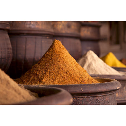Verschiedene Gewürzpulver, darunter Curry, in traditionellen Gefäßen, passend für Feinkost Sets und Liebhaber von veganen Superfood-Produkten.