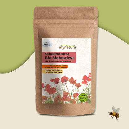 Bio Mohnwiese Saatgutmischung im Beutel auf grünem Hintergrund, unten rechts fliegende Biene, Fokus auf das Produktetikett.