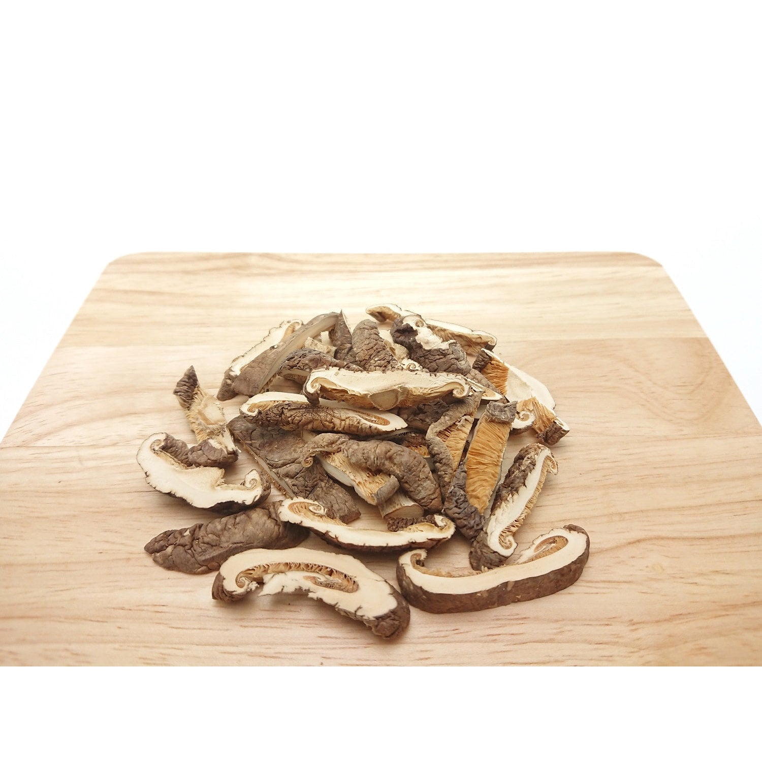 Häufchen geschnittener shiitake pilze auf einem hellen Holzbrett, pilzscheiben in unterschiedlicher Größe.