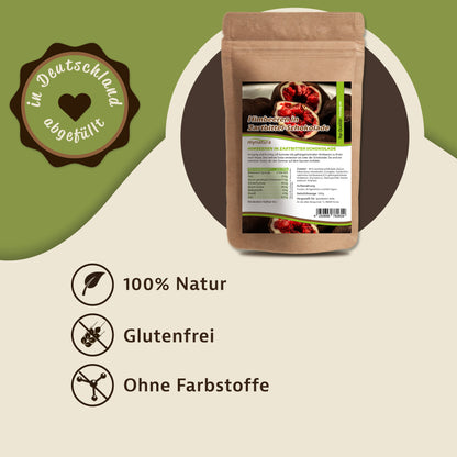 Beutel mit Etikett von gefriergetrockneten Himbeeren in Zartbitterschokolade, daneben Siegel und Symbole für natürliche und glutenfreie Snacks.