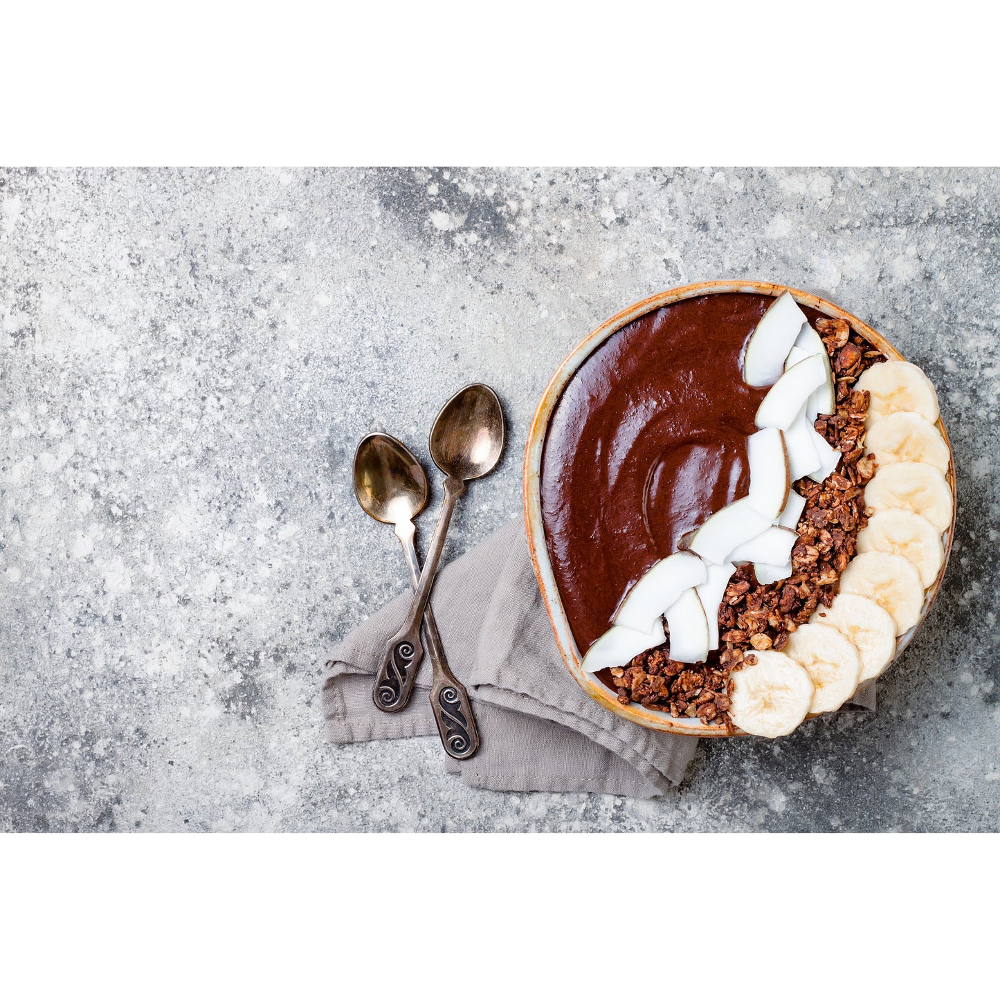 Schoko-Pudding in Schale mit Bananenscheiben, Kokosstücken und Granola, angerichtet zum Löffeln, geeignet für Pudding, protein pancakes oder superfood