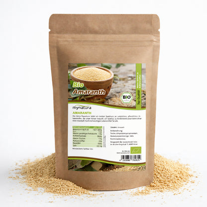 Beutel Bio Amaranth von Mynatura mit sichtbaren Amaranth-Körnern, stehend auf verstreuten Samen, Vorderseite mit Etikett und Nährwertangaben.