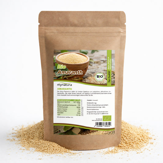 Beutel Bio Amaranth von Mynatura mit sichtbaren Amaranth-Körnern, stehend auf verstreuten Samen, Vorderseite mit Etikett und Nährwertangaben.