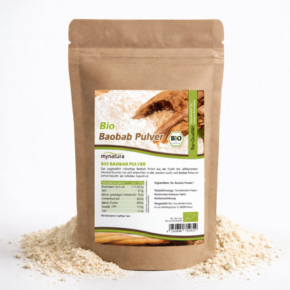 Beutel Mynatura Bio Baobab Pulver steht auf einem Haufen Baobabpulver, Vorderseite mit Etikett und Nährwertangaben sichtbar.