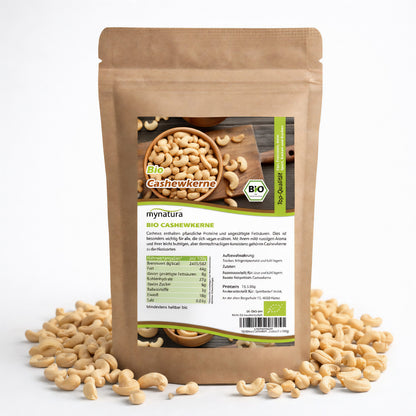 Beutel mit Bio Cashewkerne von mynatura, umgeben von losen Cashewkerne, Vorderseite mit Produktetikett und Nährwertangaben, geeignet als snacks oder für frühstück.