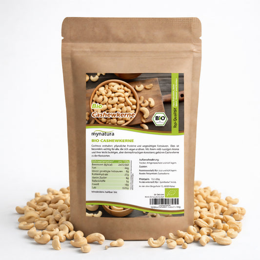 Beutel mit Bio Cashewkerne von mynatura, umgeben von losen Cashewkerne, Vorderseite mit Produktetikett und Nährwertangaben, geeignet als snacks oder für frühstück.
