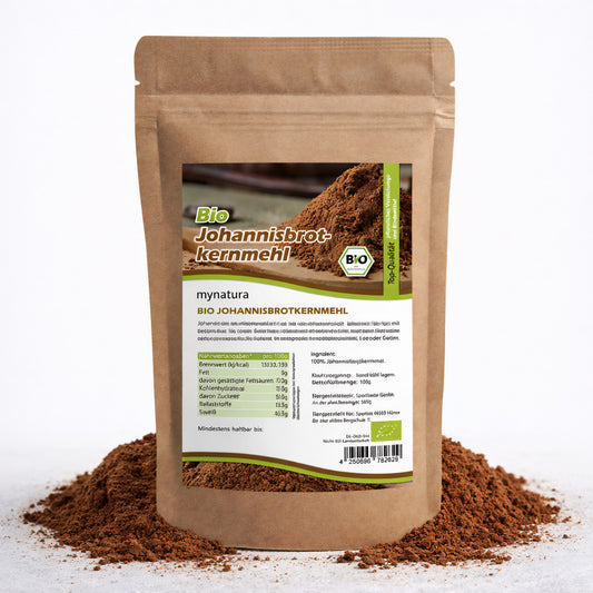 Beutel mit Etikett für Bio Johannisbrotkernmehl E410, stehend auf einem Haufen braunen Mehls, Produkt für backen, kochen und als glutenfreies verdickungsm geeignet.