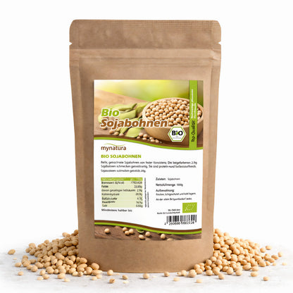 Beutel Mynatura Bio Sojabohnen als Superfood, stehend auf weißem Untergrund, umgeben von verstreuten Sojabohnen, Vorderseite mit Etikett sichtbar.