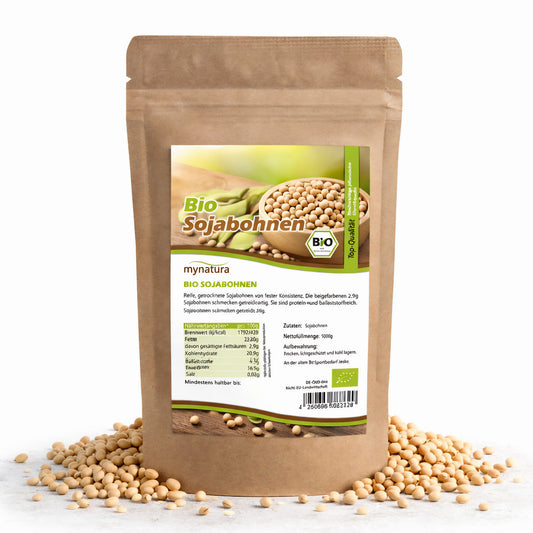 Beutel Mynatura Bio Sojabohnen als Superfood, stehend auf weißem Untergrund, umgeben von verstreuten Sojabohnen, Vorderseite mit Etikett sichtbar.