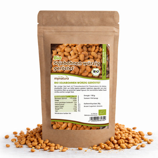 Beutel Bio Sojasnack würzig von Mynatura, stehend auf weißem Untergrund, umgeben von gerösteten Sojabohnen als veganer pflanzensnack.