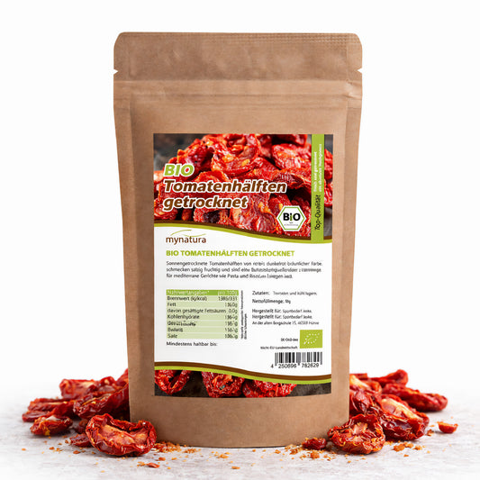 Beutel mit mynatura Bio Tomatenhälften getrocknet, stehend auf weißem Untergrund, umgeben von getrockneten Tomaten als Snacks.