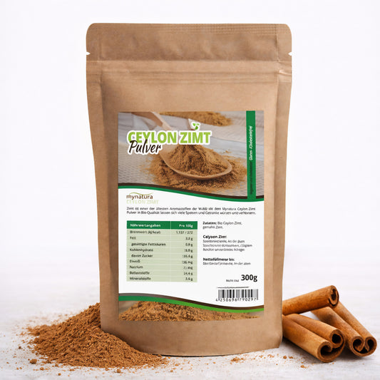 Beutel mit Mynatura Bio Ceylon Zimt Pulver 300g, vorne Etikett sichtbar, daneben Zimtstangen und Zimtpulver auf weißem Untergrund.