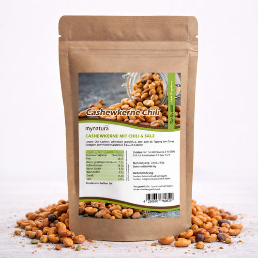 Beutel mit Mynatura Cashewkerne mit Chili und Salz, 500g, auf weißem Untergrund, umgeben von gerösteten Nüssen und Kernen als würziger Snack.