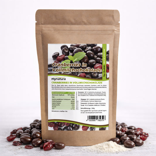 Beutel mit Mynatura cranberries in vollmilchschokolade, umgeben von schokolierten cranberries und getrockneten früchten auf weißem Untergrund.