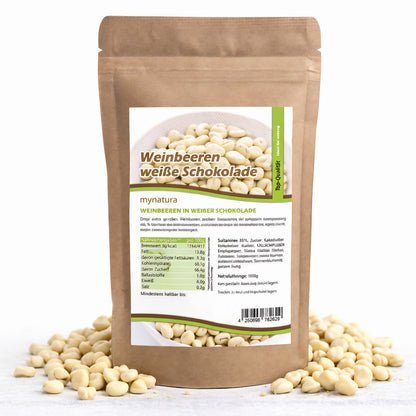 Beutel mit Mynatura weinbeeren in weißer schokolade, umgeben von verstreuten schoko weinbeeren auf weißem Untergrund.