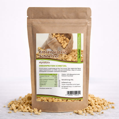 Beutel Mynatura Erbsenprotein Schnetzel 600g auf weißem Hintergrund, umgeben von losen veganen Schnetzel-Stücken.