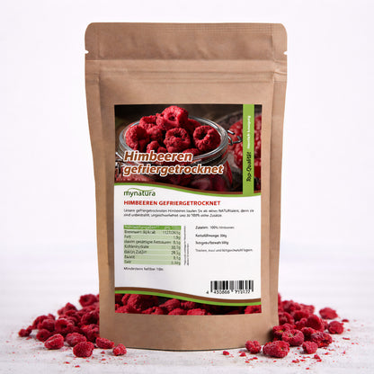 Beutel mit gefriergetrockneten Himbeeren von Mynatura, 500g, aufrecht stehend, umgeben von verstreuten Früchten, Vorderseite mit Etikett und Nährwertangaben sichtbar.