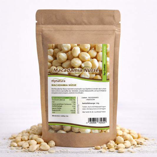 Beutel mit Mynatura Macadamiakerne 500g, braune Verpackung mit Sichtfenster und Produktetikett, umgeben von losen macadamia nüsse auf weißem Untergrund.