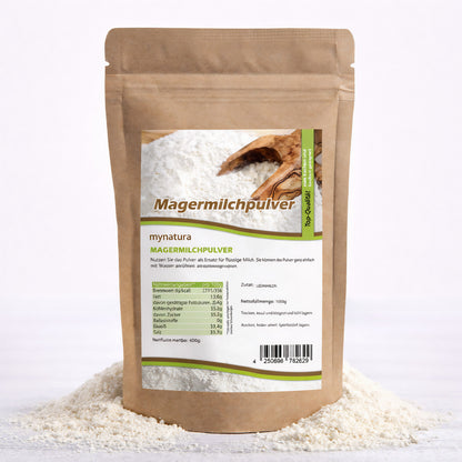 Beutel Magermilchpulver von Mynatura auf einem Haufen fettarmes Trockenmilchpulver, Vorderseite mit Etikett und Nährwertangaben, geeignet zum Backen und Kochen.