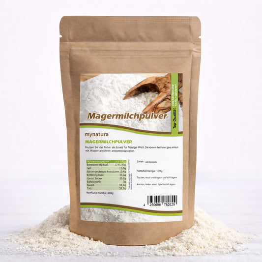 Beutel Magermilchpulver von Mynatura auf einem Haufen fettarmes Trockenmilchpulver, Vorderseite mit Etikett und Nährwertangaben, geeignet zum Backen und Kochen.