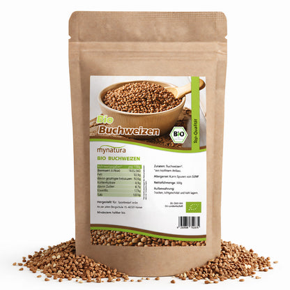 Beutel Mynatura Bio Buchweizen 500g, stehend auf weißem Hintergrund, mit sichtbaren Buchweizen-Kernen und Produktetikett, einige Kerne liegen lose um die Verpackung.