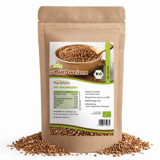 Beutel Mynatura Bio Buchweizen 500g, stehend auf weißem Hintergrund, mit sichtbaren Buchweizen-Kernen und Produktetikett, einige Kerne liegen lose um die Verpackung.