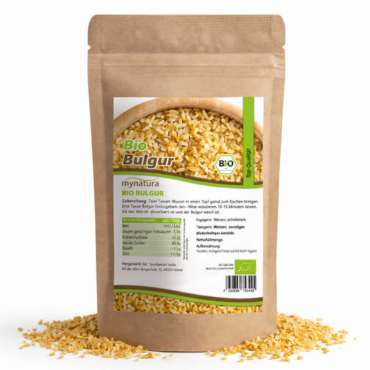 Beutel Mynatura Bio Bulgur mit durchsichtigem Sichtfenster, gefüllt mit gelbem Bulgur, auf weißem Hintergrund, einige Körner liegen verstreut davor, geeignet für vegane Gerichte und Salate.