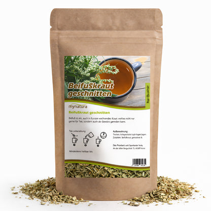 Beutel mit beifußkraut, 100g, von mynatura, aufrecht stehend, umgeben von losem, geschnittenem kraut, Vorderseite mit Etikett und Teetasse abgebildet.