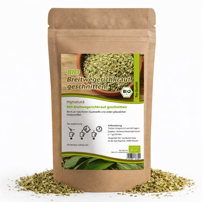 Beutel mit mynatura getrocknetem und geschnittenem Breitwegerichkraut, 100g, auf weißem Hintergrund, Kräuter rund um die Verpackung verstreut.