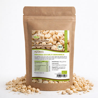 Beutel mit Bio erdmandeln ganz geschält von mynatura, stehend auf weißem Untergrund, umgeben von losen erdmandeln als ballaststoffreiche snacks oder zutaten fürs müsli
