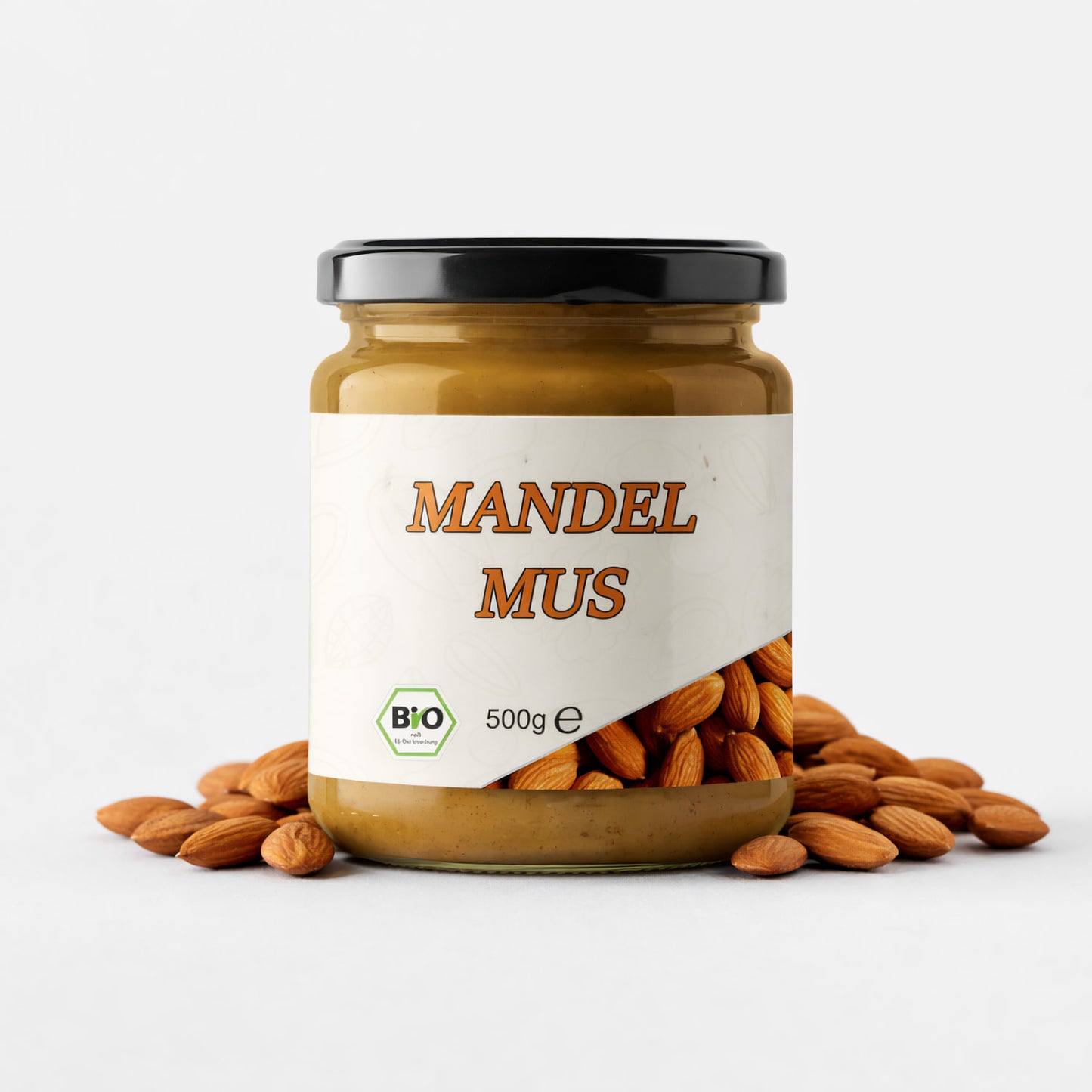 Bio Mandelmus im Glas mit 500g Inhalt, vor dem Glas liegen ganze Mandeln auf weißem Untergrund.