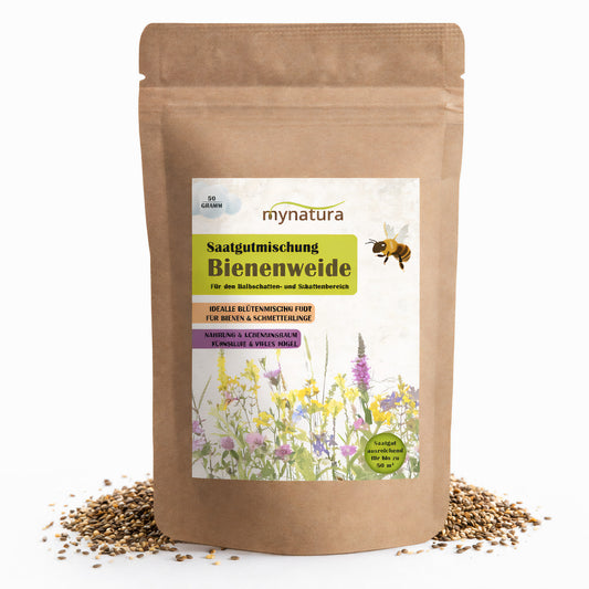Bienenweide Saatgutmischung im braunen Standbeutel mit Etikett, umgeben von verstreutem Saatgut, geeignet für Garten, Halbschatten und Schattenbereich.