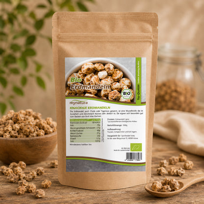 Bio Erdmandeln ganz von Mynatura im 1000g Beutel auf Holztisch, daneben ein Glas mit Erdmandeln und ein Holzlöffel, ideal für Frühstück oder als Nüsse & Kerne Snack.