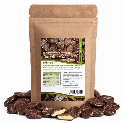 Beutel mit mynatura Bananenchips in Zartbitterschokolade, umgeben von einzelnen schokofrüchte und einem angeschnittenen bananenchip, Vorderseite mit Nährwerttabelle sichtbar.