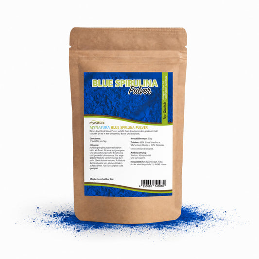 Beutel mit blauem Spirulina Pulver von Mynatura, auf weißem Hintergrund mit verstreutem intensiv blauen Pulver davor.
