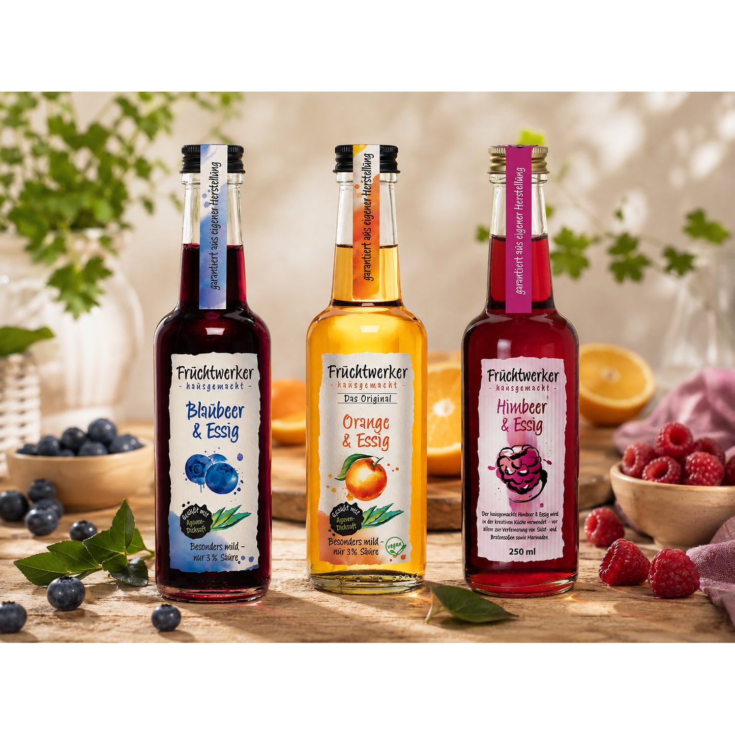 Fruchtwerker Essig und Frucht Set mit den Sorten Blaubeere, Orange und Himbeere, arrangiert auf einem Holztisch mit frischen Früchten und Kräutern im Hintergrund.