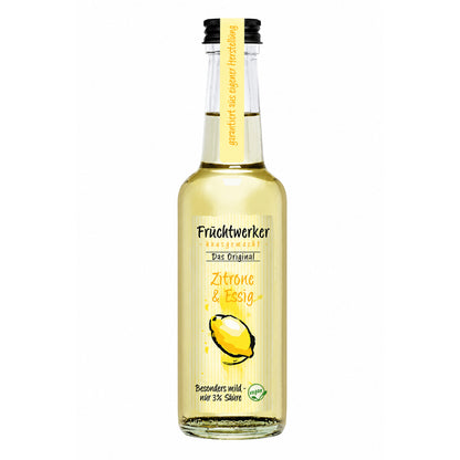 Flasche Fruchtwerker Zitrone & Essig mit gelbem Etikett und Zitronenabbildung, stehend vor weißem Hintergrund.